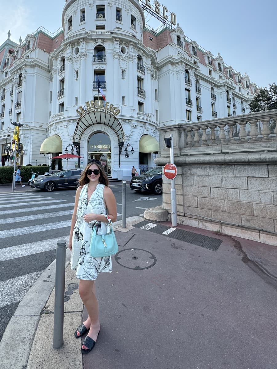 Juliana in front of a grand belle-époque hotel on the French Riviera