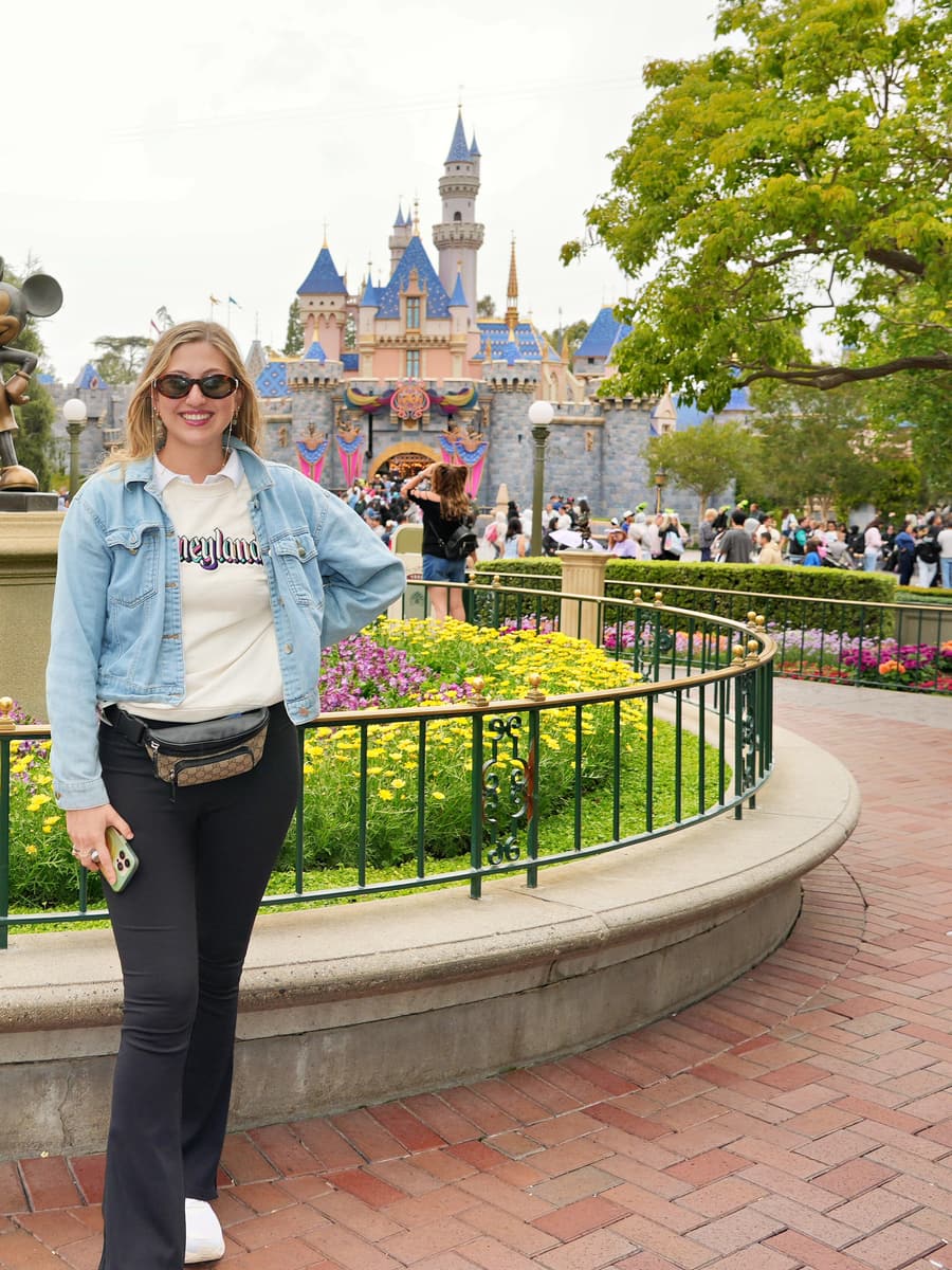 Juliana beside the Partners statue with the castle behind her at Disneyland