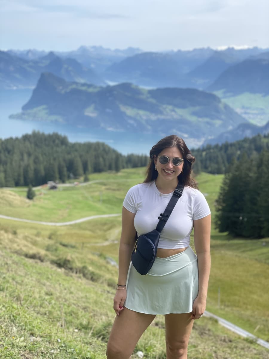 Juliana on an alpine meadow with mountains and a lake behind her