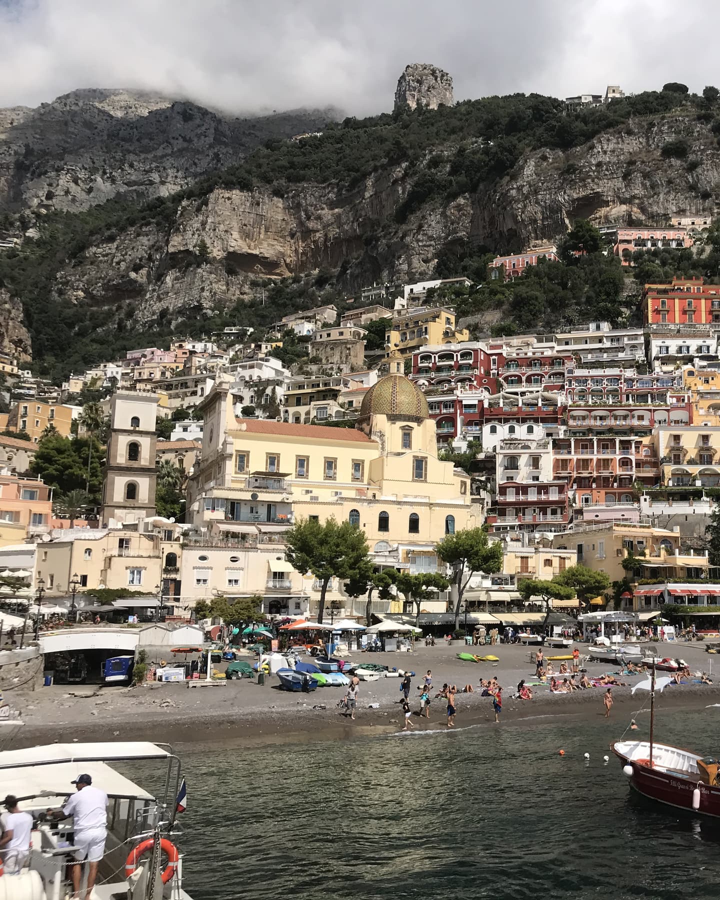 The pastel houses of Positano stacked up the cliffside above the beach