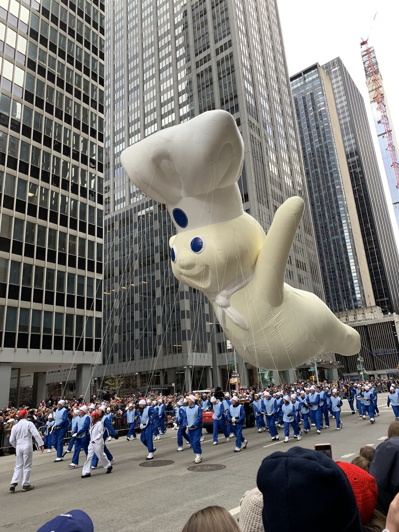 A balloon floating between skyscrapers during a city parade